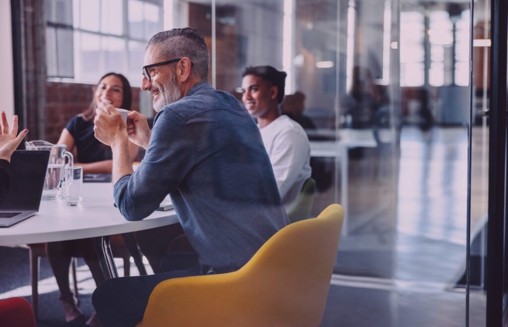 Cheerful-Businessman-Attending-a-Meeting-with-His-Team