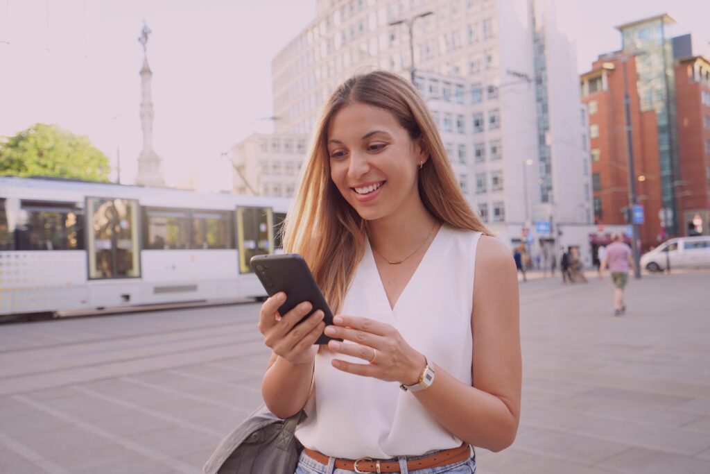 Surprised-Business-Woman-Watching-and-Texting-on-Mobile-Phone-Walking-in-City-Street