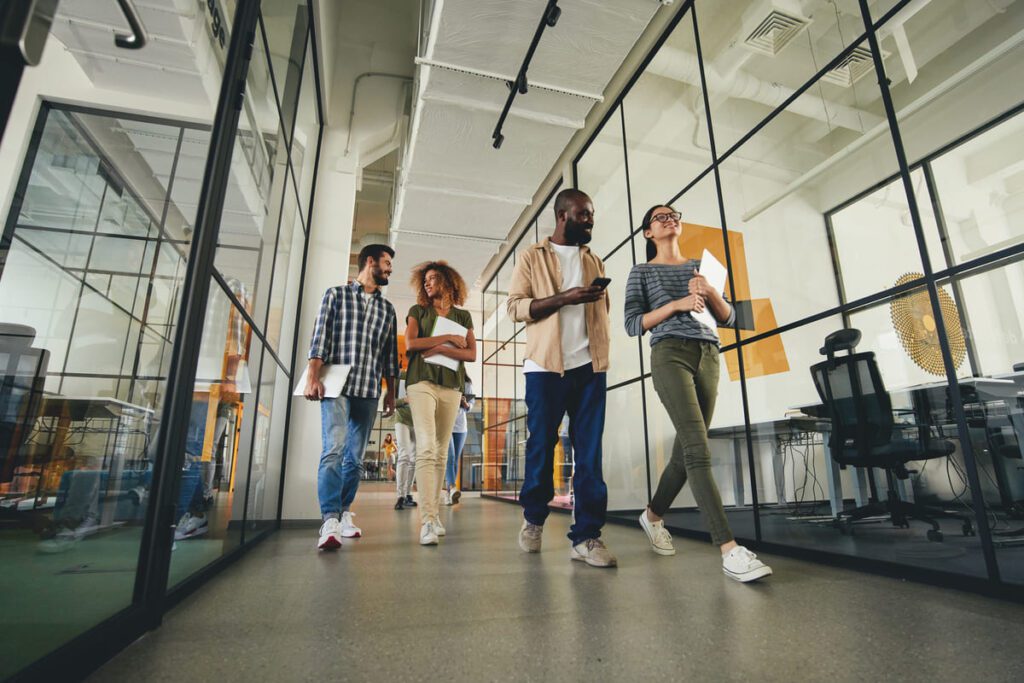 Group of people walking through hallway in modern office